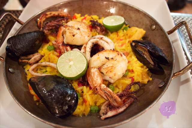 PAELLA DEL MAR Black tiger shrimp, sea scallop, calamari, mussels, saffron rice with chicken, green pea, red bell pepper, artichoke, saffron aioli, pimenton & oregano – Hojiblanca Olive Oil Plenty of seafood. But this Paella needs could use a 3rd piece of lime, but otherwise, very good plate.